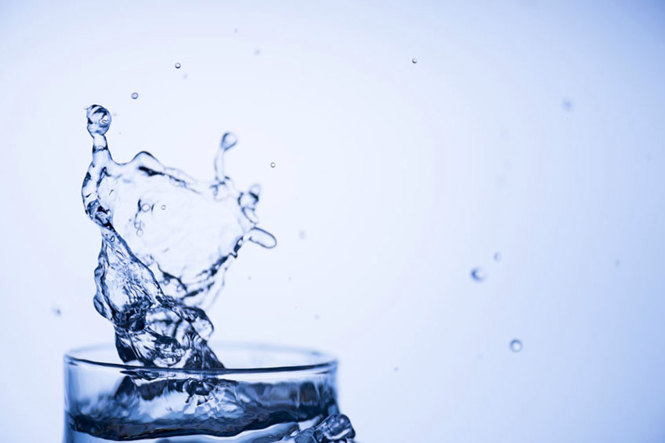 importance of staying well hydrated, glass of water splashing
